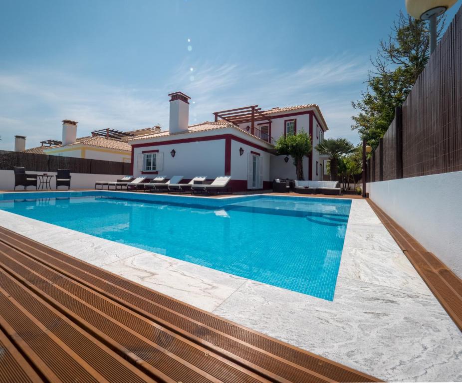 a swimming pool with a house in the background at Romã do Meco in Aldeia do Meco