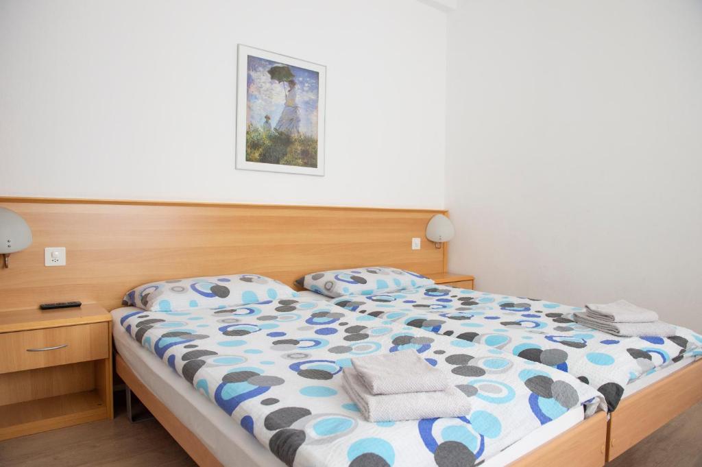 a bedroom with a bed with a blue and white comforter at Garni Moderno in Bellinzona