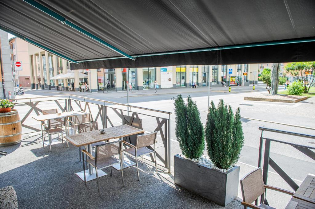 a patio with tables and chairs on a city street at Garni Moderno in Bellinzona