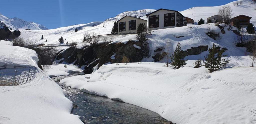 a house on a snow covered mountain with a stream at Curtinfess Franklin in Bivio