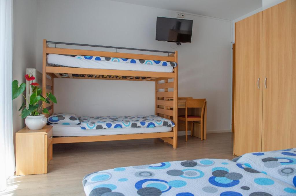 a bedroom with two bunk beds and a tv at Garni Moderno in Bellinzona