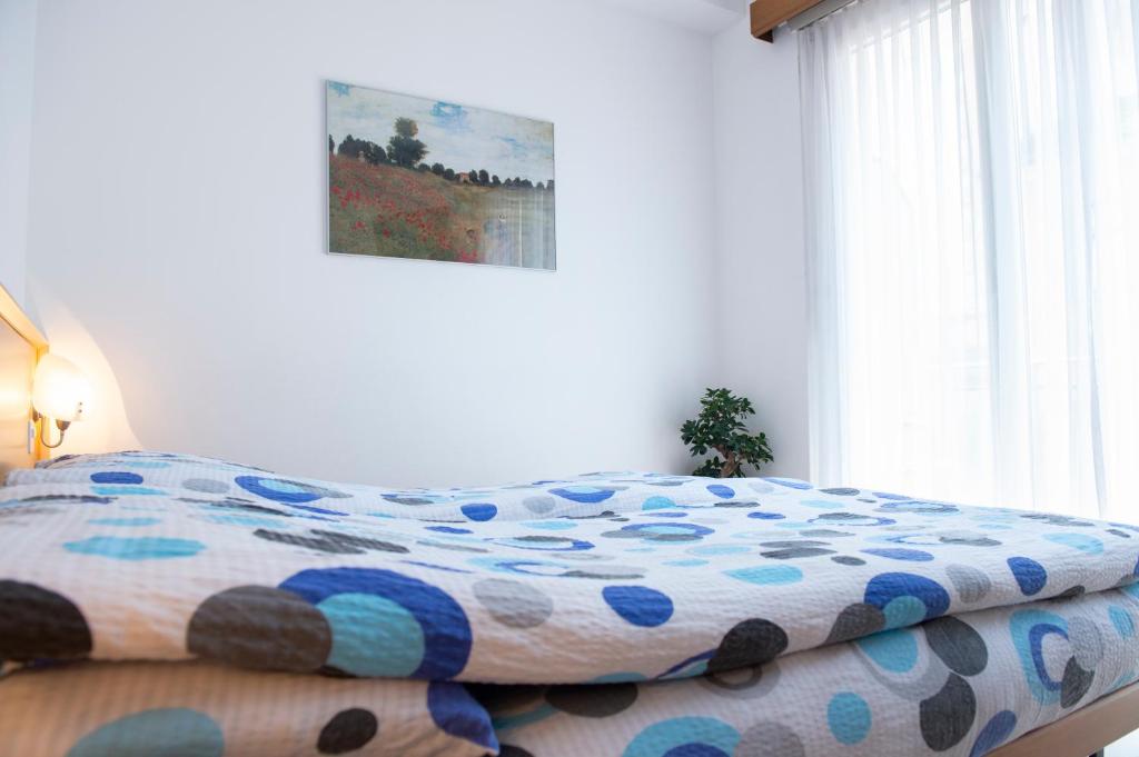 a bed with a colorful comforter in a bedroom at Garni Moderno in Bellinzona