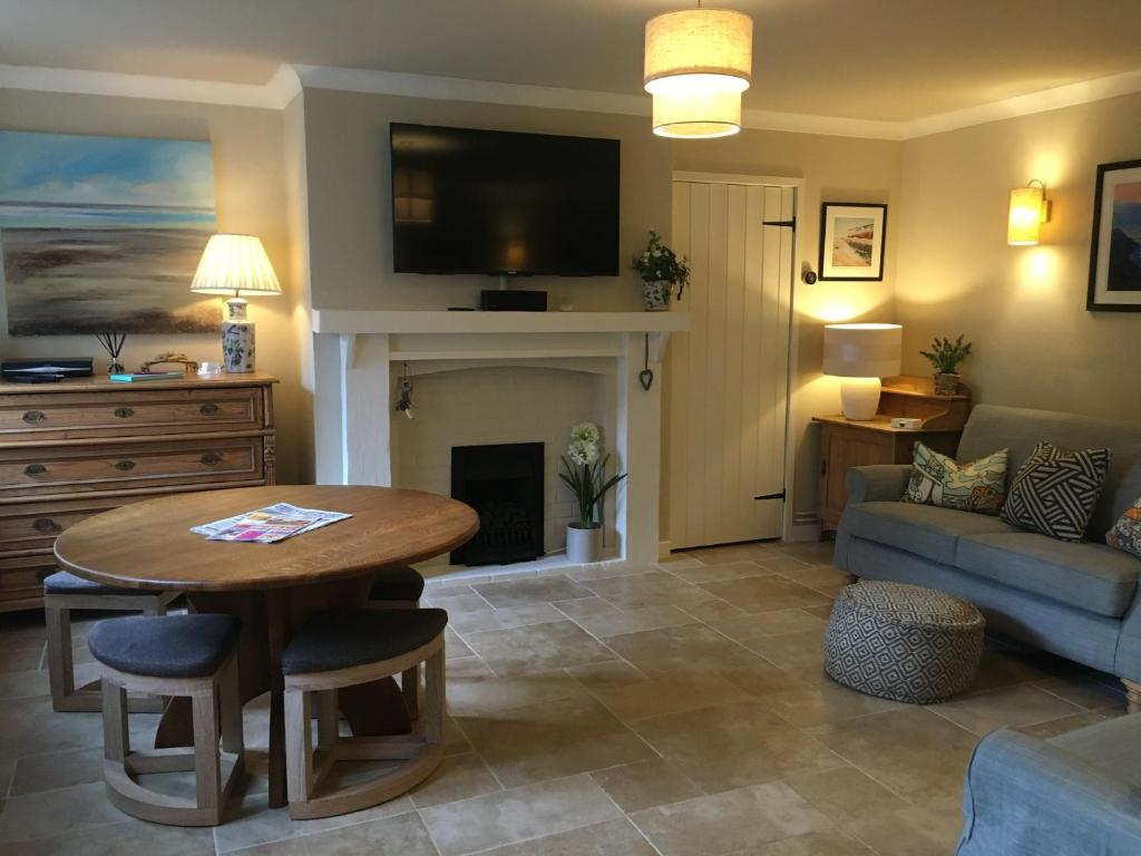 a living room with a table and a couch at 9 Melinda Cottage in Cromer