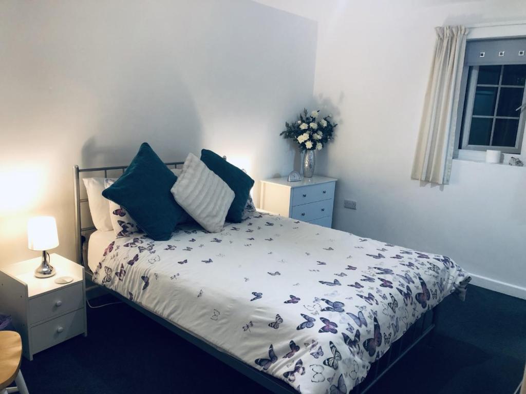 a bedroom with a bed with blue pillows on it at The Cottage in Redruth