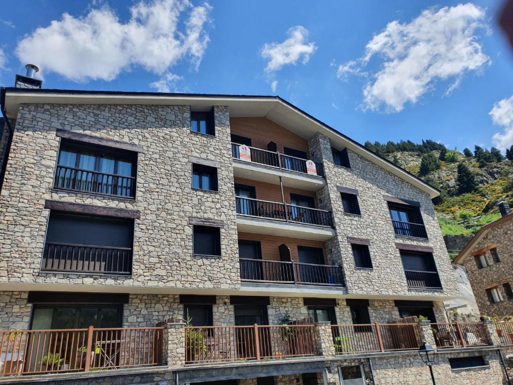 an apartment building with balconies on a hill at Apartamentos Grifo Vacances Julia in El Tarter