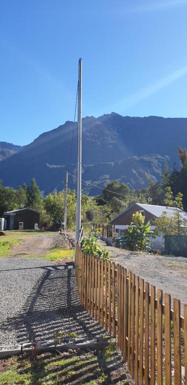 een hek aan de kant van een weg met een berg bij La caz' à Chisy in Cilaos