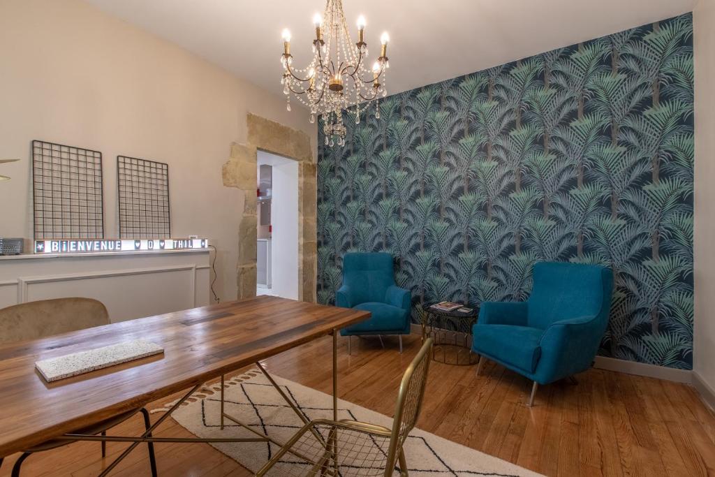 a dining room with a table and blue chairs at Othil in Aire-sur-lʼAdour