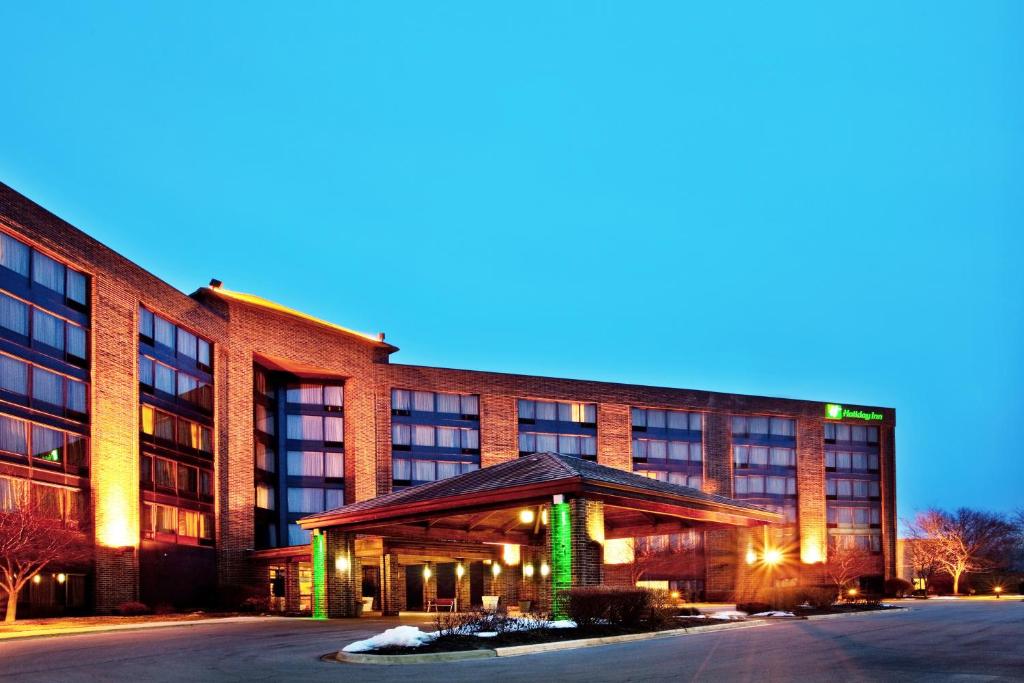 a large red brick building with green lights at Holiday Inn Chicago Nw Crystal Lk Conv Ctr by IHG in Crystal Lake