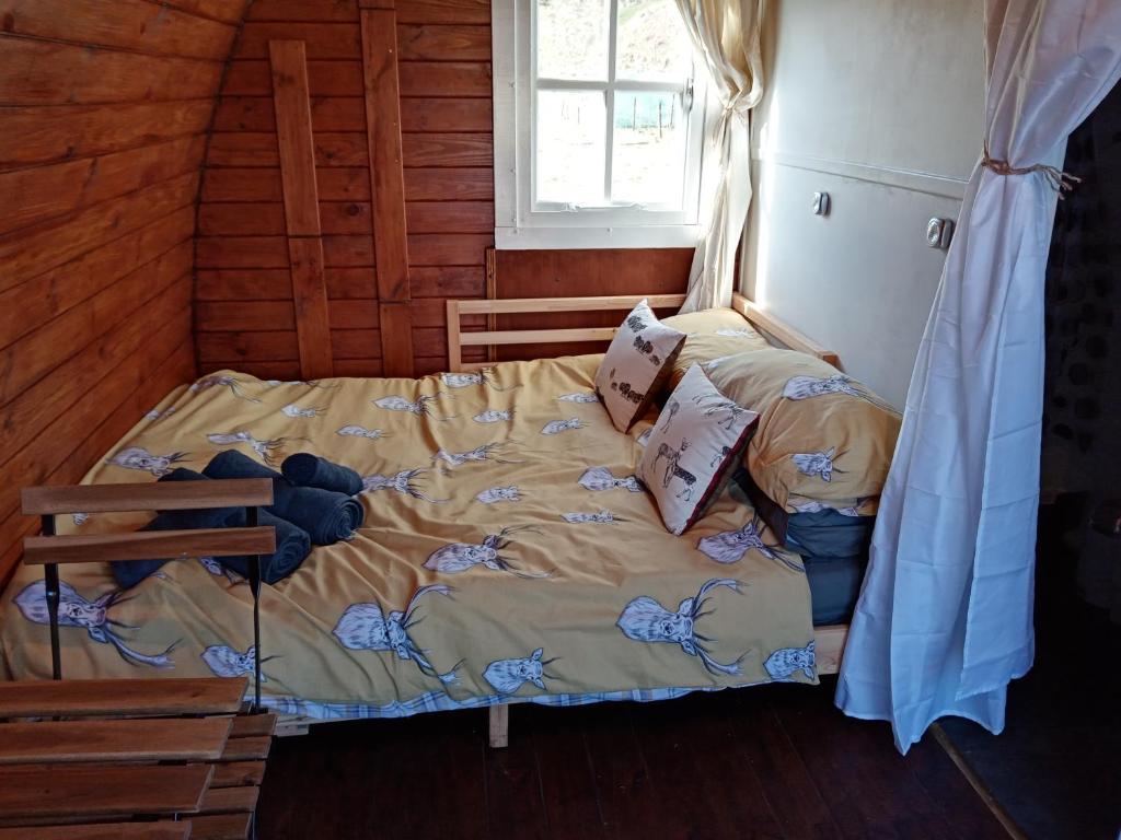 1 dormitorio con 1 cama en una cabaña de madera en Wee Hoose Glaping Pod 2, en Skail