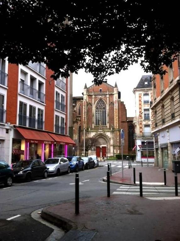 une rue de la ville avec des voitures garées devant une église dans l'établissement Hyper-Centre historique avec possibilité de réservation parking, à Toulouse