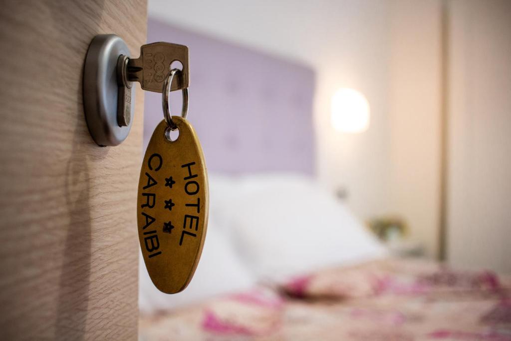 リミニにあるHotel Caraibiの寝室のドアから掛けられた鍵札