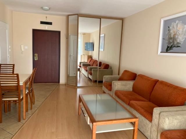 a living room with a couch and a table at Apartament Reymonta przy morzu in Kołobrzeg