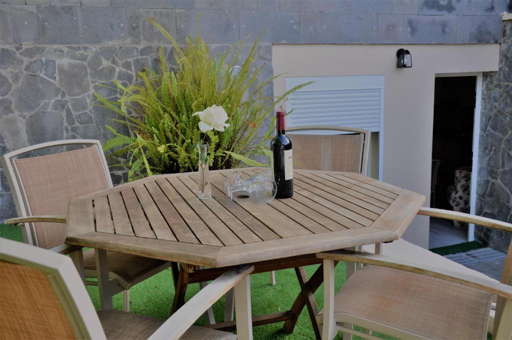 ein Holztisch mit einer Flasche Wein darauf in der Unterkunft Villa Alegria in Santa Brígida