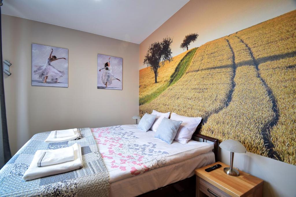 sypialnia z łóżkiem z obrazem na ścianie w obiekcie Aparthotel Globus - bezkontaktowa obsługa w Łodzi