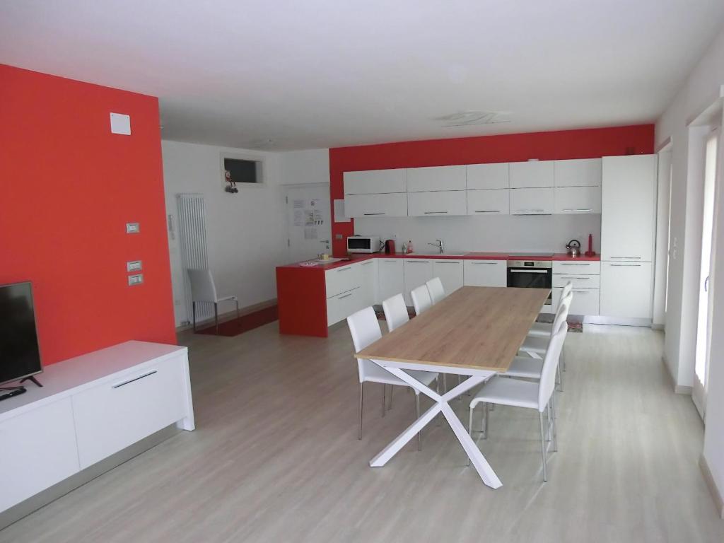 uma cozinha com uma mesa de madeira e armários brancos em cima Monticelli em Passo del Tonale