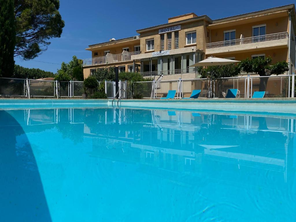 a large swimming pool in front of a building at Logis Hôtel Le Clement V in Roquemaure