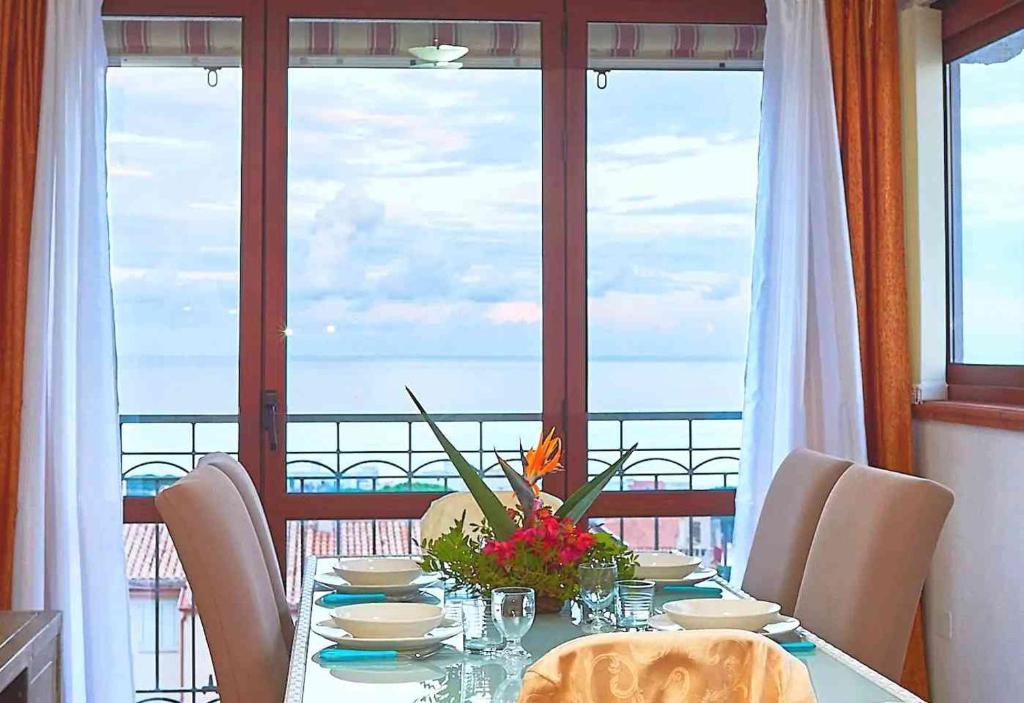 uma mesa de jantar com vista para o oceano em Amazing View Home em Cala Gonone
