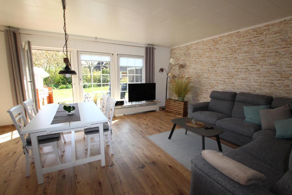 Seeteufel Büsum في بوسوم: غرفة معيشة مع طاولة بيضاء وأريكة