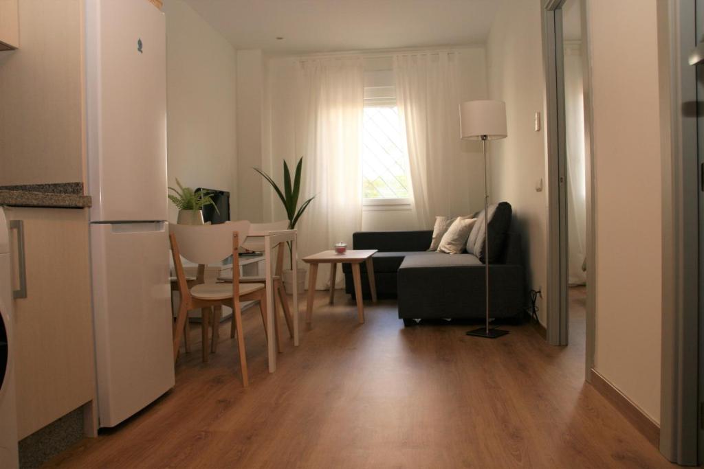 - un salon avec un canapé et une table dans l'établissement Apartamentos Apartour Bormujos, à Bormujos