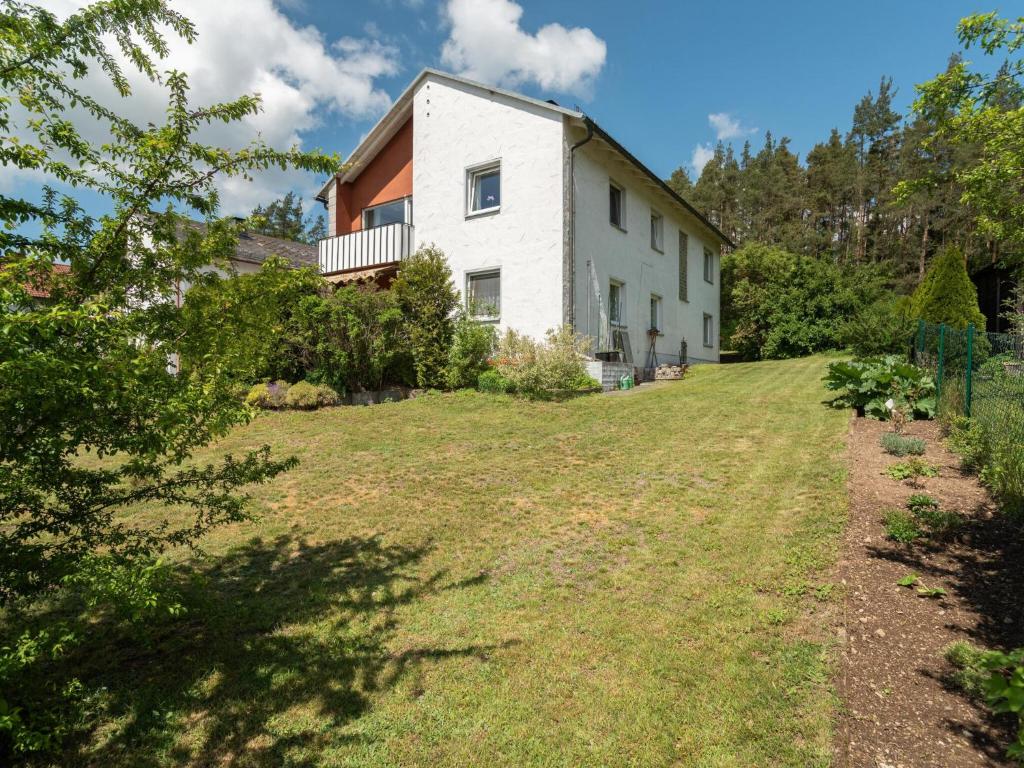 a white house on a hill with a yard at Tranquil Apartment in Marktleuthen near River and Forest in Marktleuthen