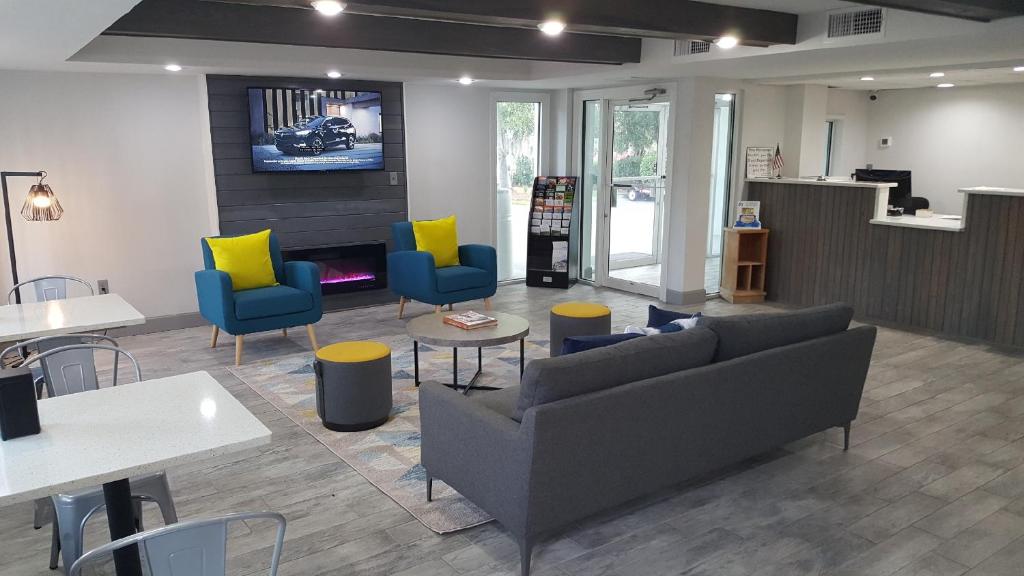 a living room with couches and chairs and tables at Days Inn by Wyndham Ridgeland South Carolina in Ridgeland