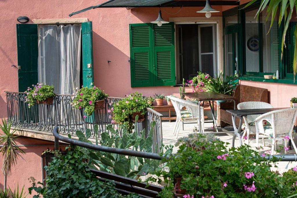 a pink house with a balcony with tables and chairs at B&B Da Beppe in Neirone