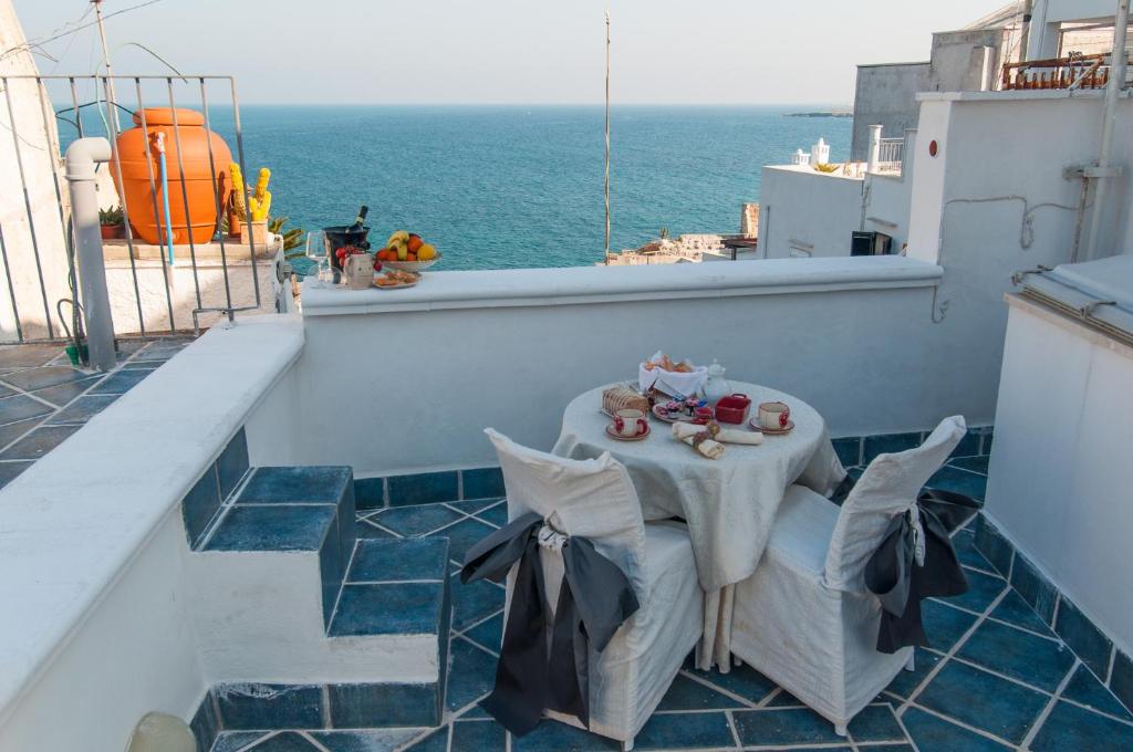 a table on a balcony with the ocean in the background at Anna's Rose Holiday Home in Monopoli