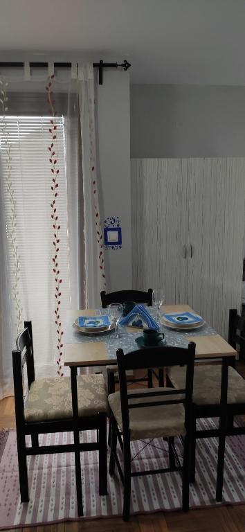 a dining room table with two chairs and a table with plates at Apartment Marjana in Zlatibor