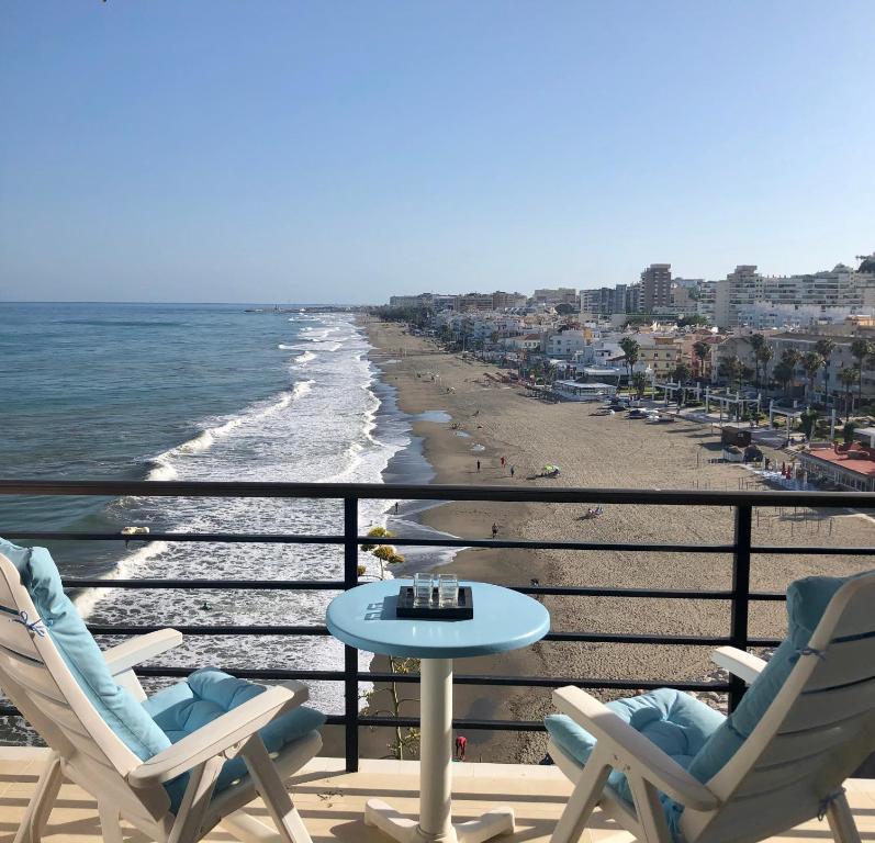 een balkon met stoelen en een tafel en het strand bij Castillo Santa Clara in Torremolinos
