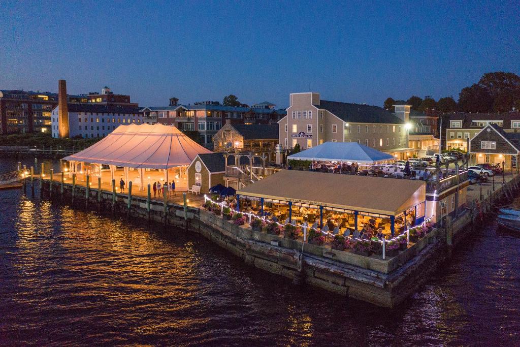 a dock with a restaurant on the water at night at Bristol Harbor Inn in Bristol