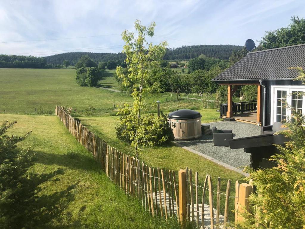 een achtertuin met een hek en een grill bij Kustelberg Lodges in Medebach