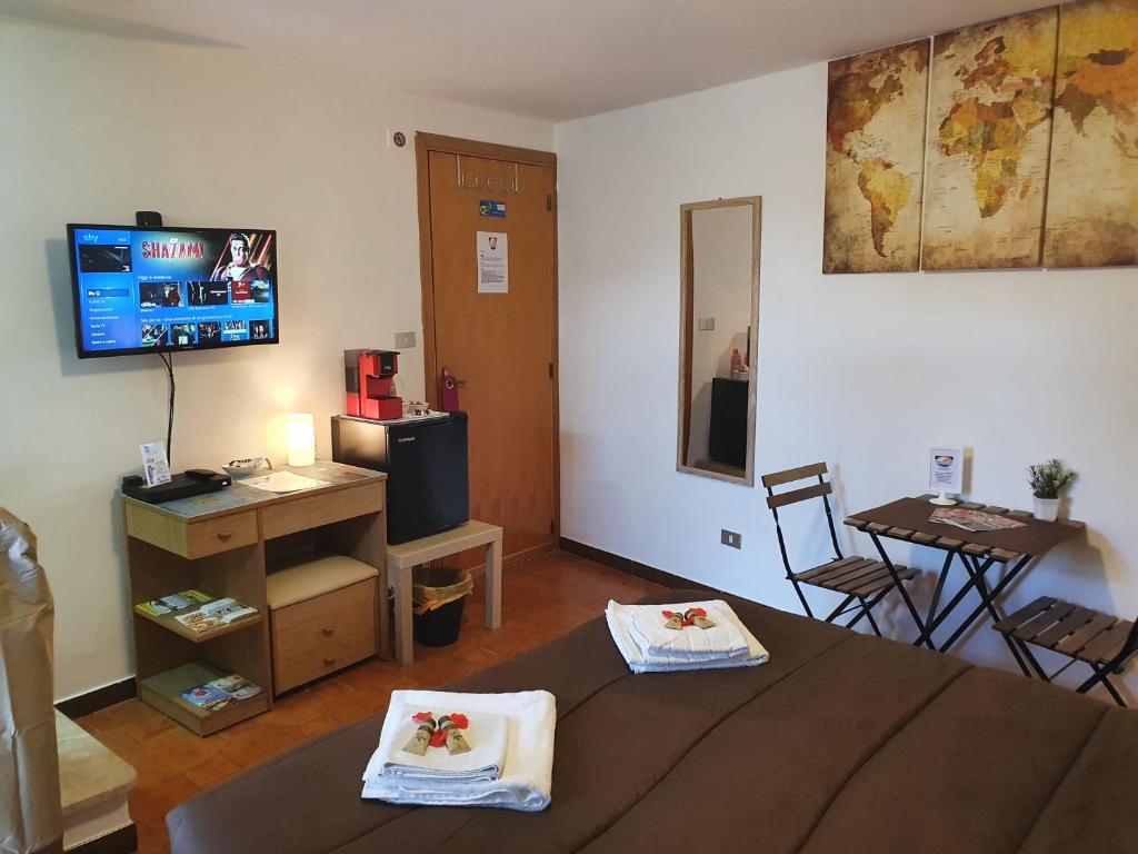 Habitación con cama, TV y mesa. en Via CASALE en San Cataldo
