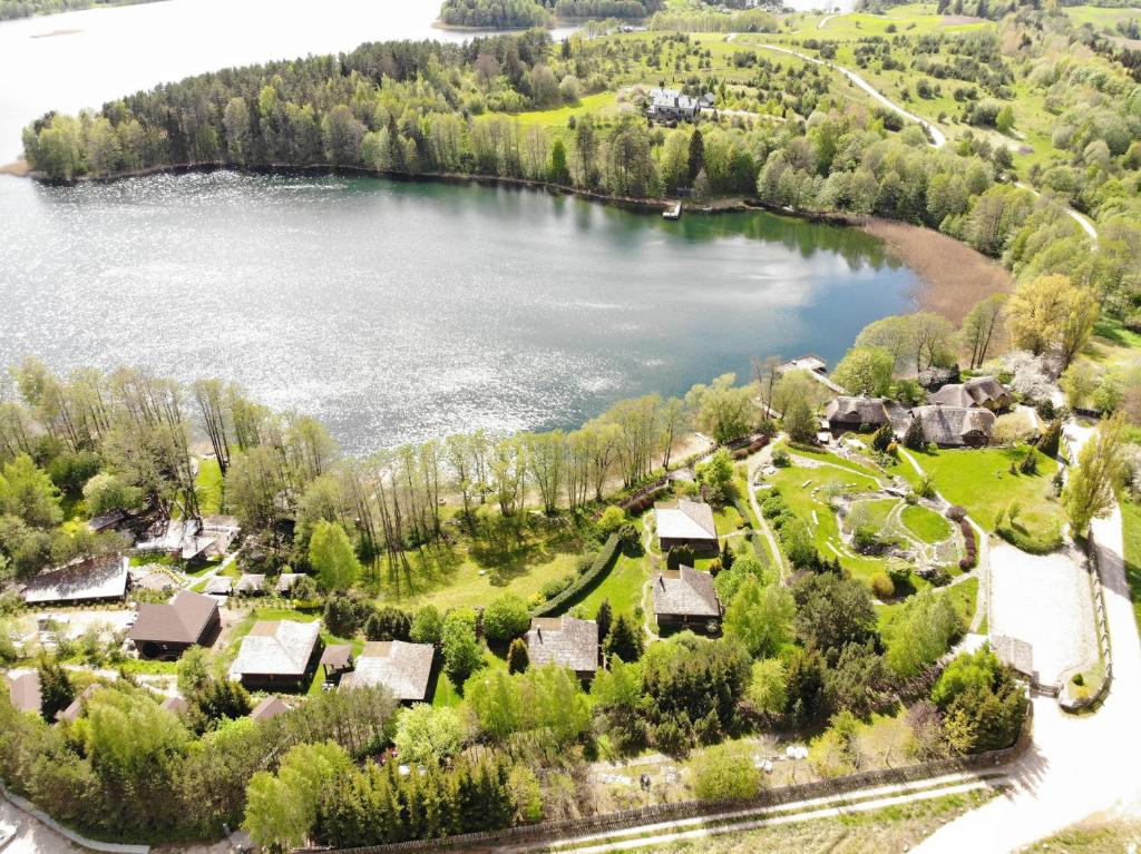 an aerial view of a lake with houses at Akmenos Villas & Bungalow in Bražuolė