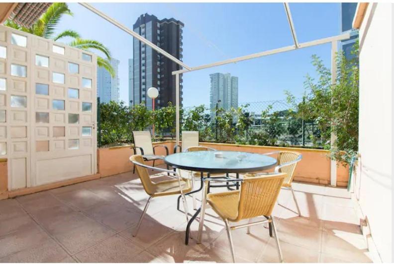 een patio met een tafel en stoelen op een balkon bij Apartamento Xixo in Benidorm