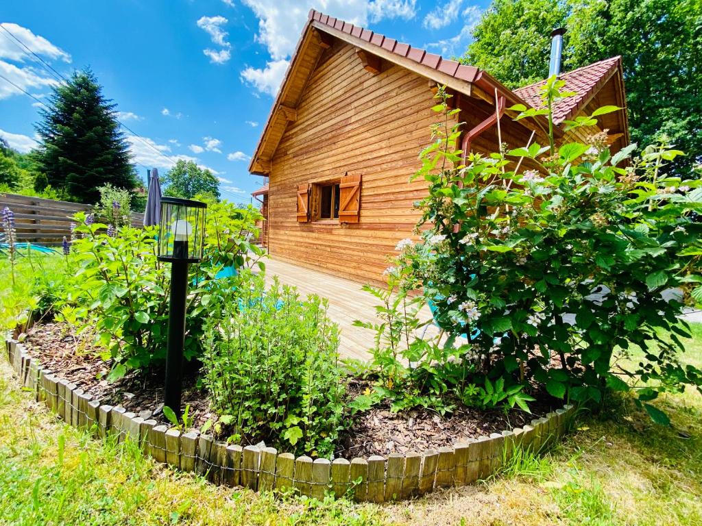 a garden in front of a wooden house at Le Hygge Chalet Gérardmer-Spa in Anould