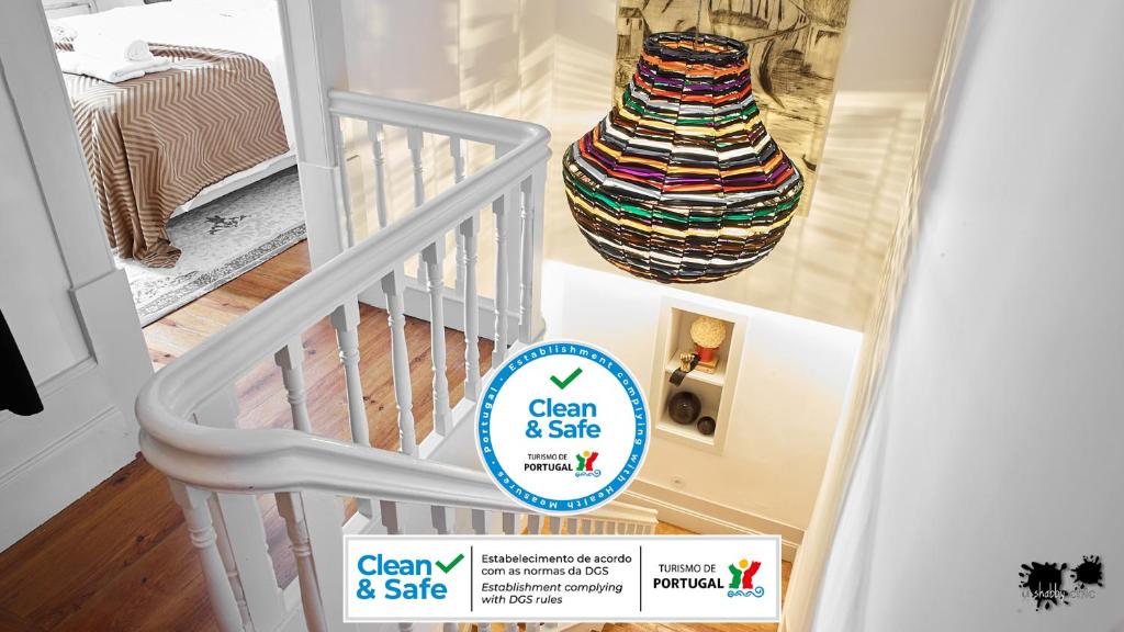 a white staircase with a sign that says clean and safe at República Guest House in Coimbra