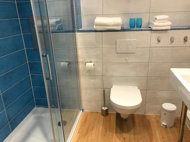 ein Badezimmer mit Toilette und Glasdusche in der Unterkunft Moin ! in Timmendorfer Strand