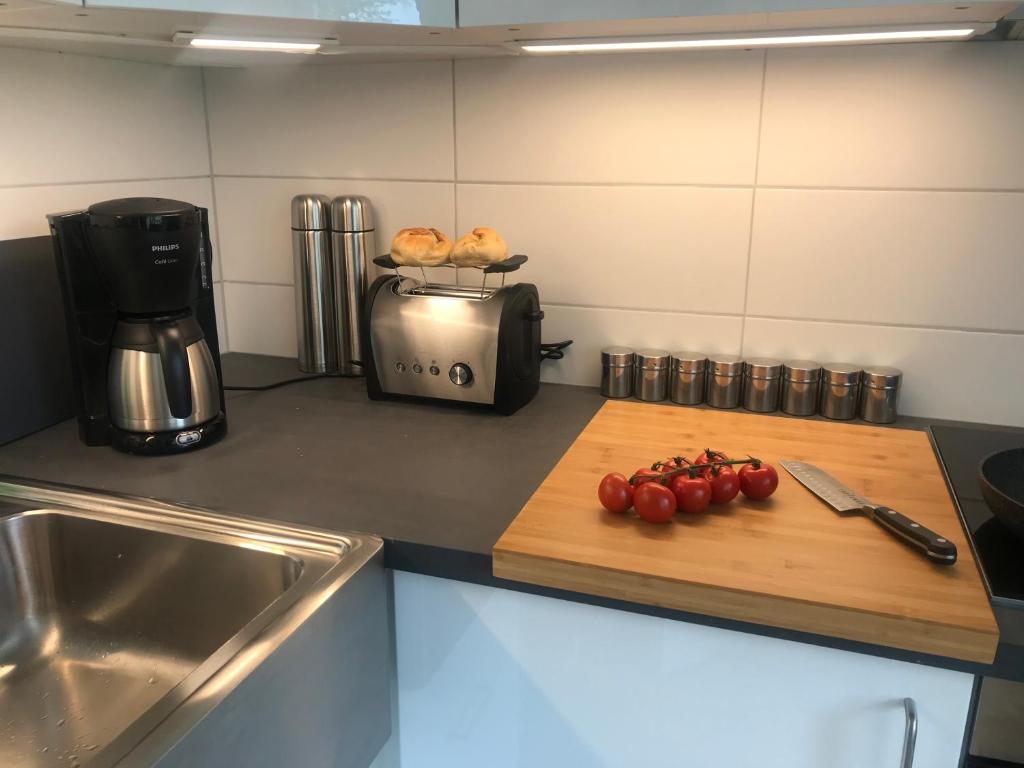 eine Küchentheke mit einem Schneidebrett mit Tomaten darauf in der Unterkunft Moin ! in Timmendorfer Strand
