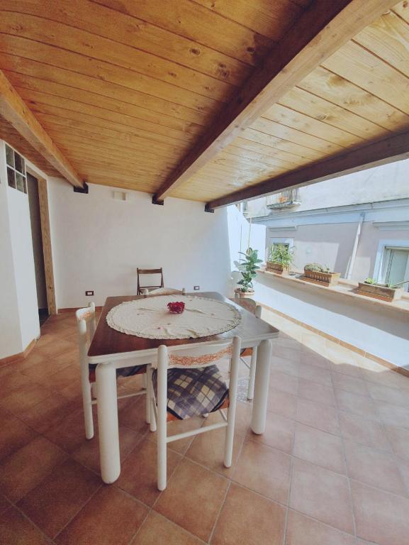a table and chairs in a room with a wooden ceiling at Il Borgo Apartment in Gaeta