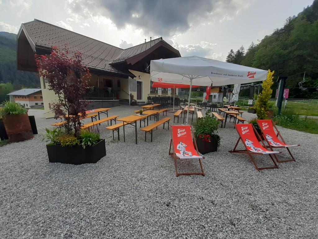 a group of tables and chairs with umbrellas at Liftstüberl Hintersee in Hintersee