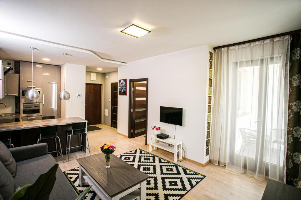 a living room and kitchen with a couch and a table at Murano Apartaments in Warsaw