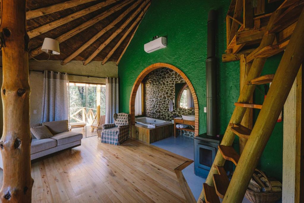 a living room with green walls and a wooden staircase at Curucaca Hotel Brasil in Bom Retiro