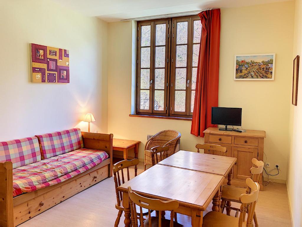 uma sala de estar com um sofá e uma mesa em Appartement 107 Résidence du Grand Hotel Aulus-les-Bains em Aulus-les-Bains