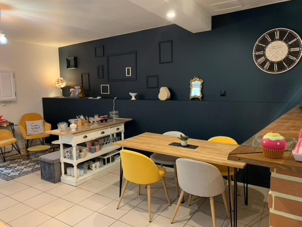 a kitchen with a table and chairs and a clock on the wall at Chambre d'hôtes Logis de Saint Jean in Bayeux