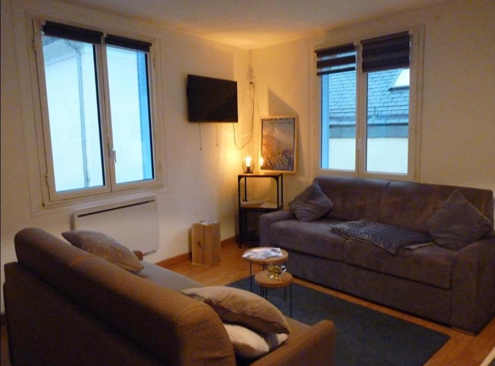 un salon avec un canapé et une télévision dans l'établissement Cauterets centre village 19 couchages, à Cauterets