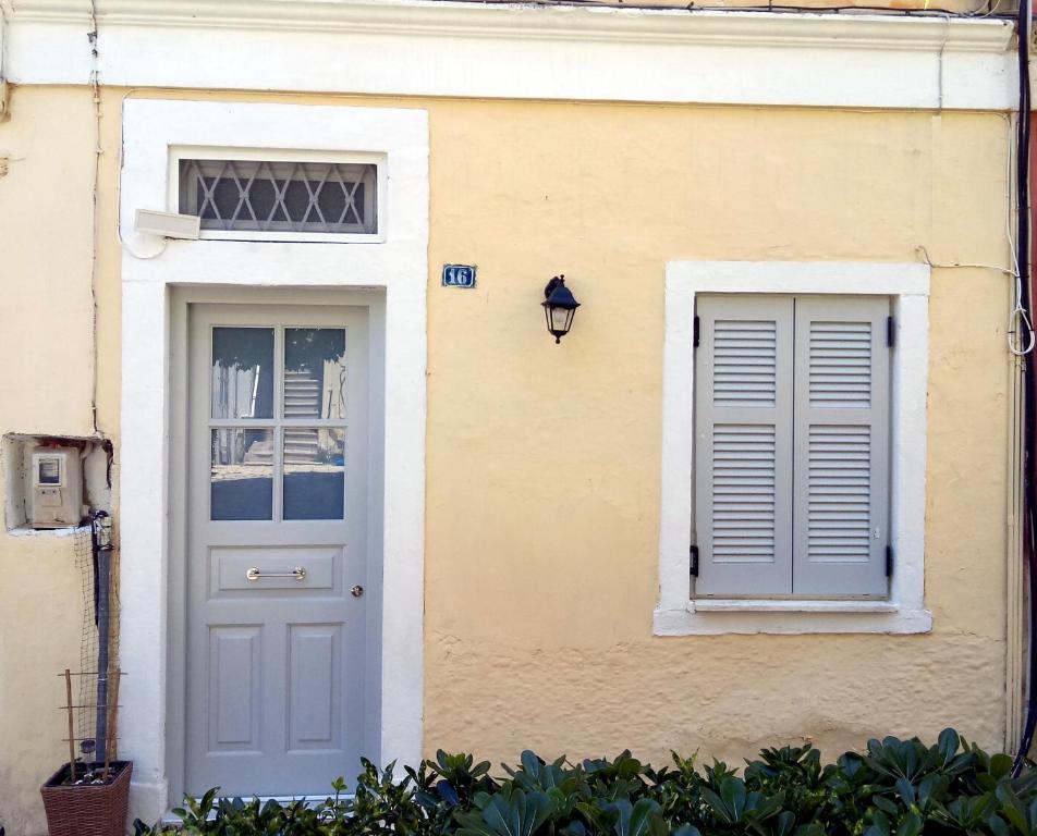 a house with a white door and a window at DOWNTOWN Mavili's Studio in Corfu