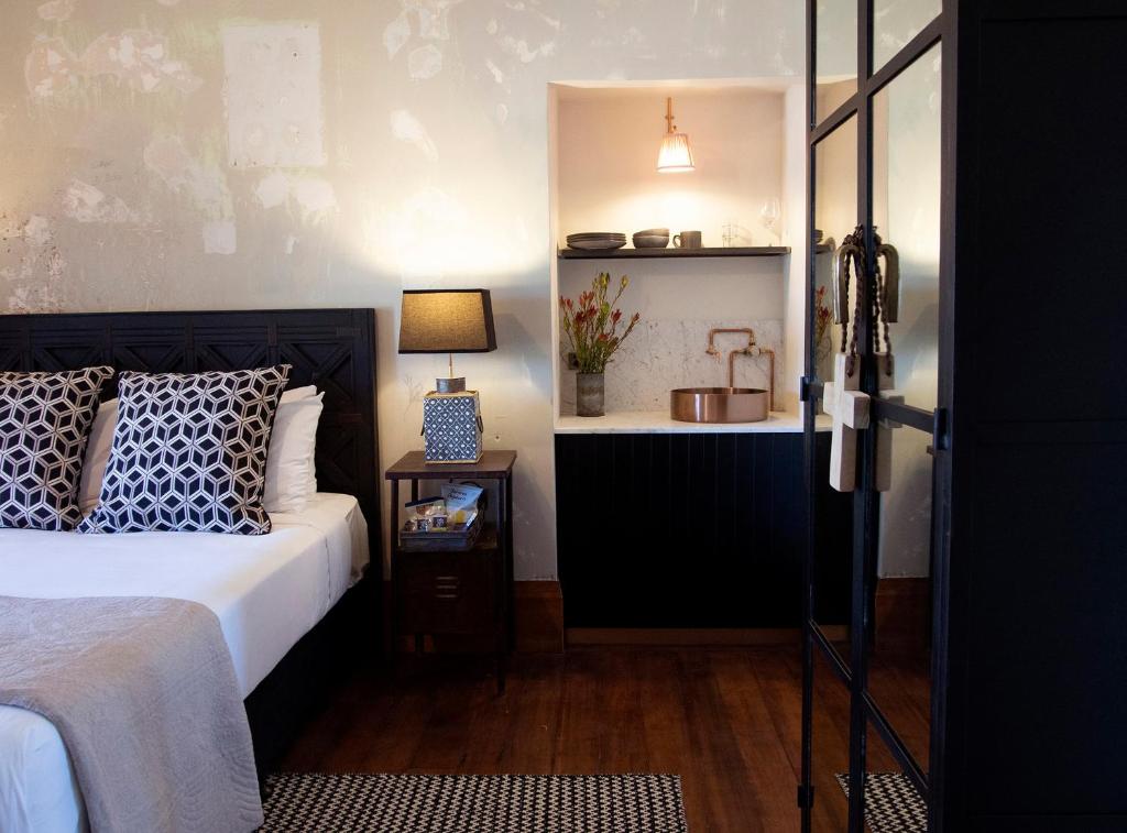 a bedroom with a bed and a table with a lamp at The Convent Hotel in Auckland
