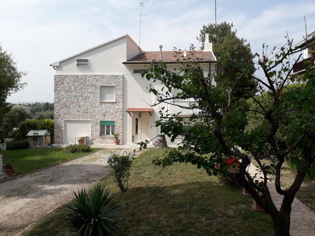 a white house with a tree in front of it at Affittacamere Tory in Sirolo