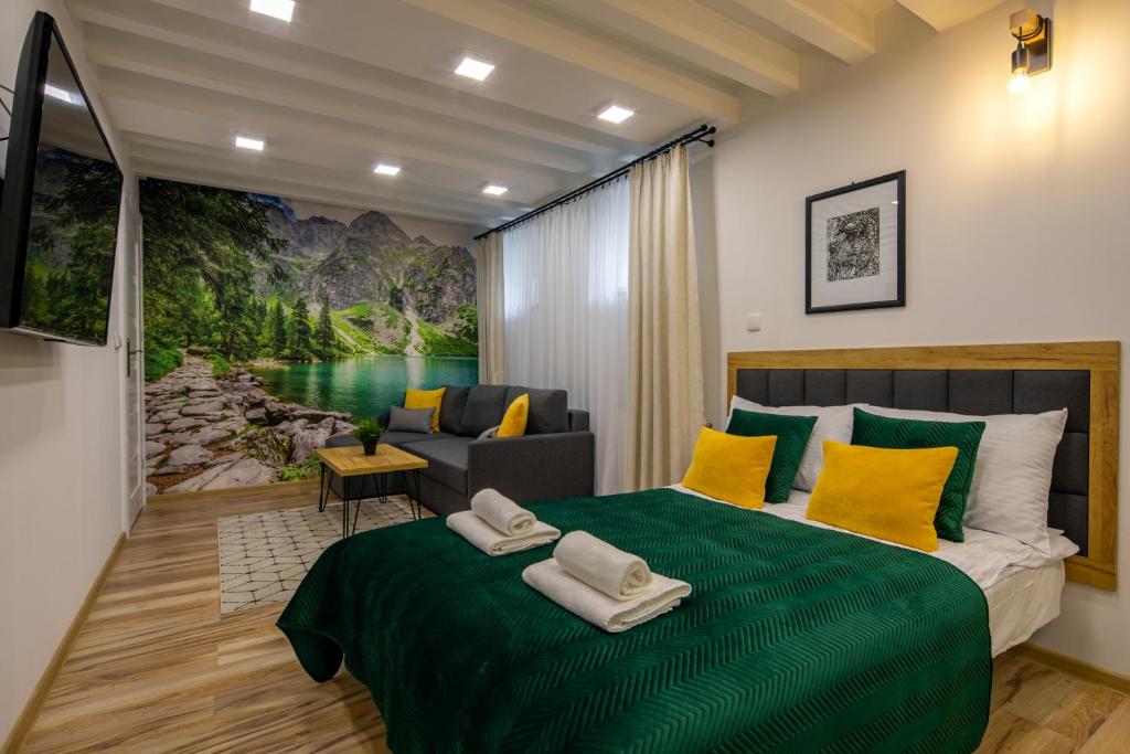 a bedroom with a large green bed with yellow pillows at PIWNICZKA - Pokoje Zakopane Centrum in Zakopane