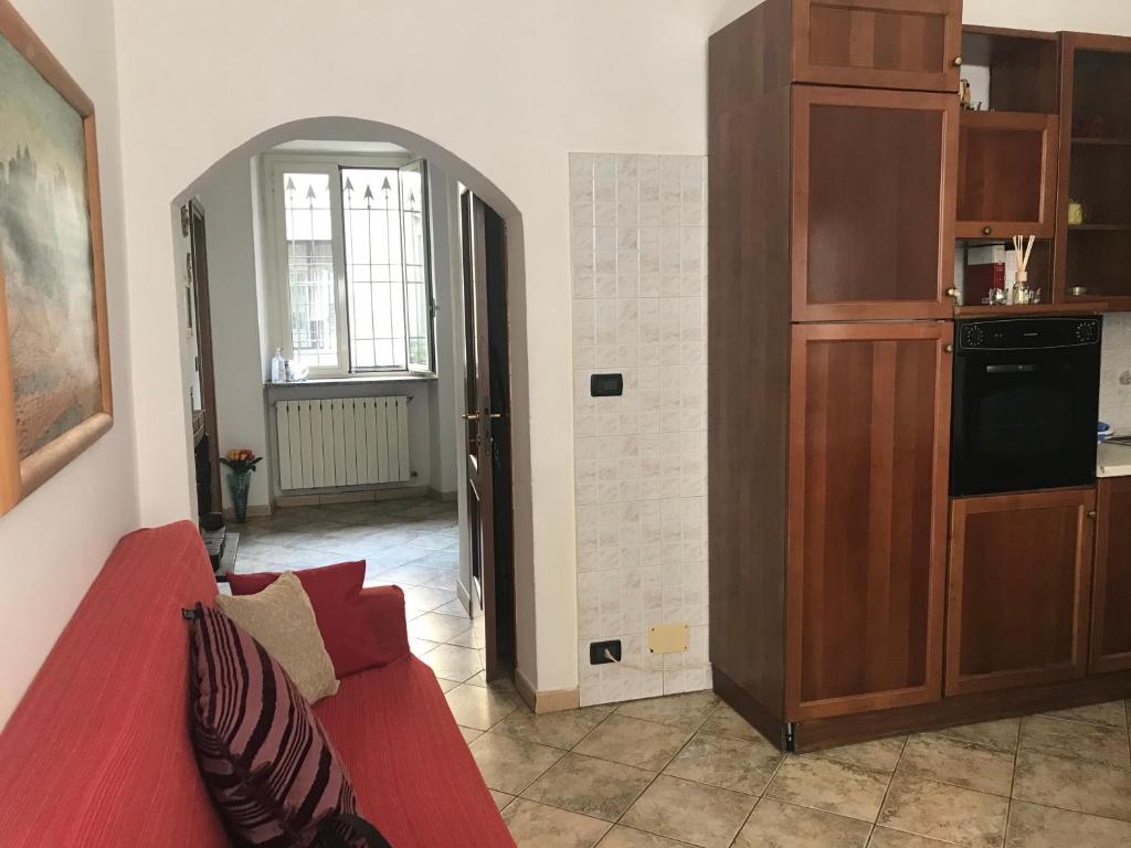 un soggiorno con divano rosso e una cucina di Casa Serena a Torino